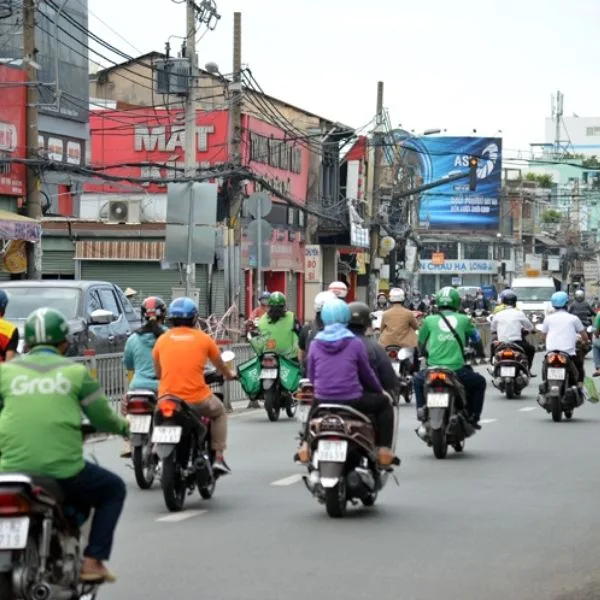 Dòng người di chuyển dưới nắng gắt tại Việt Nam. Việc lựa chọn màu sắc áo khoác không chỉ là sở thích mà còn là bài toán khoa học giữa khả năng phản xạ nhiệt và hấp thụ tia UV